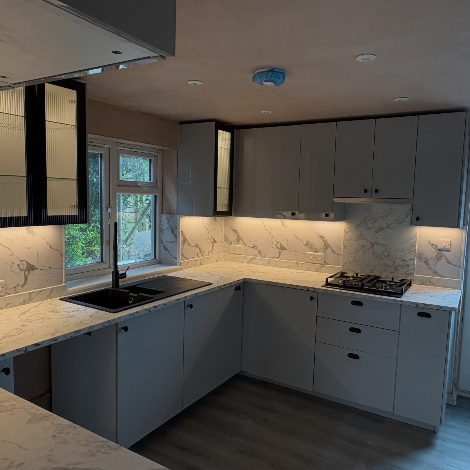 Grey kitchen with marble worktops and splashback